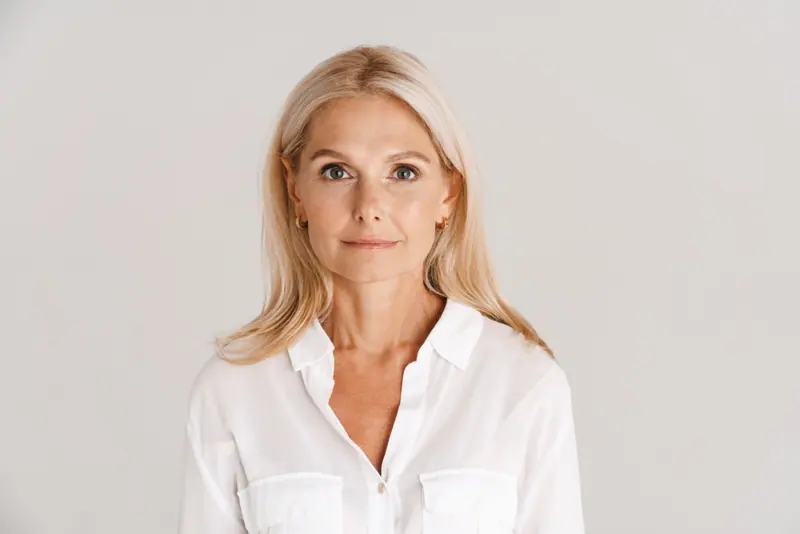 Elegant woman poses in white shirt indoors