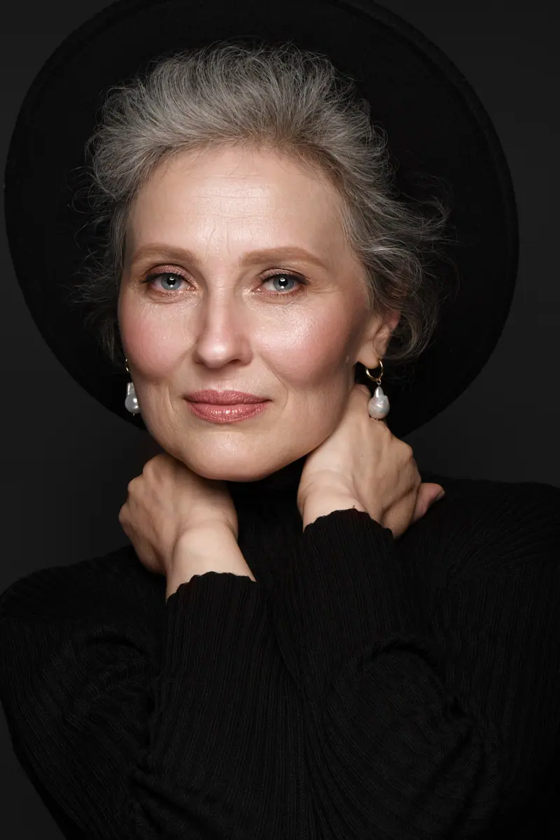 Elegant woman posing with black hat and earrings