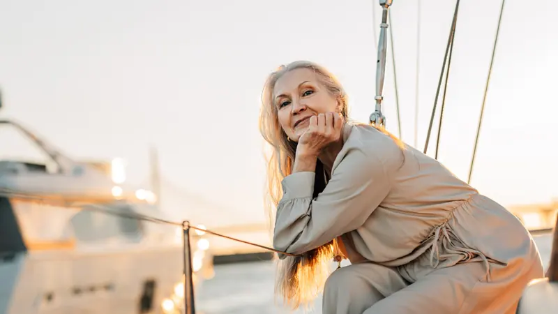 Elegant woman relaxing on yacht at sunset