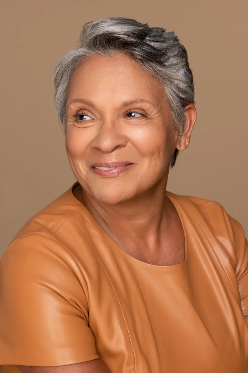 Elegant woman with gray hair and amber top