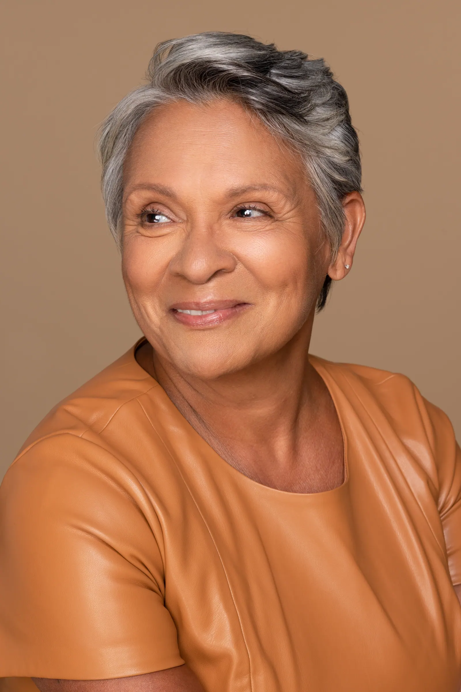 Elegant woman with gray hair and amber top