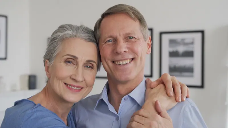 Happy mature couple smiles in their cozy home