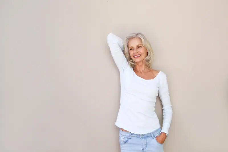 Happy mature woman in jeans and top posing