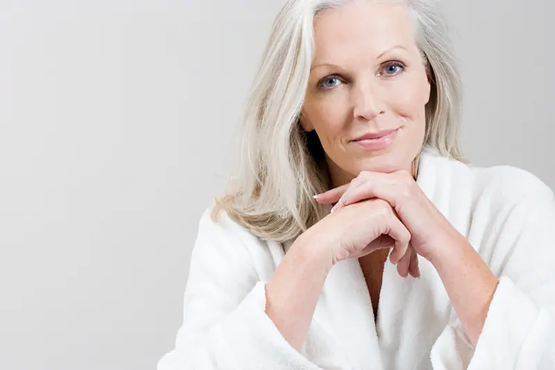 Relaxing woman in bathrobe with silver hair