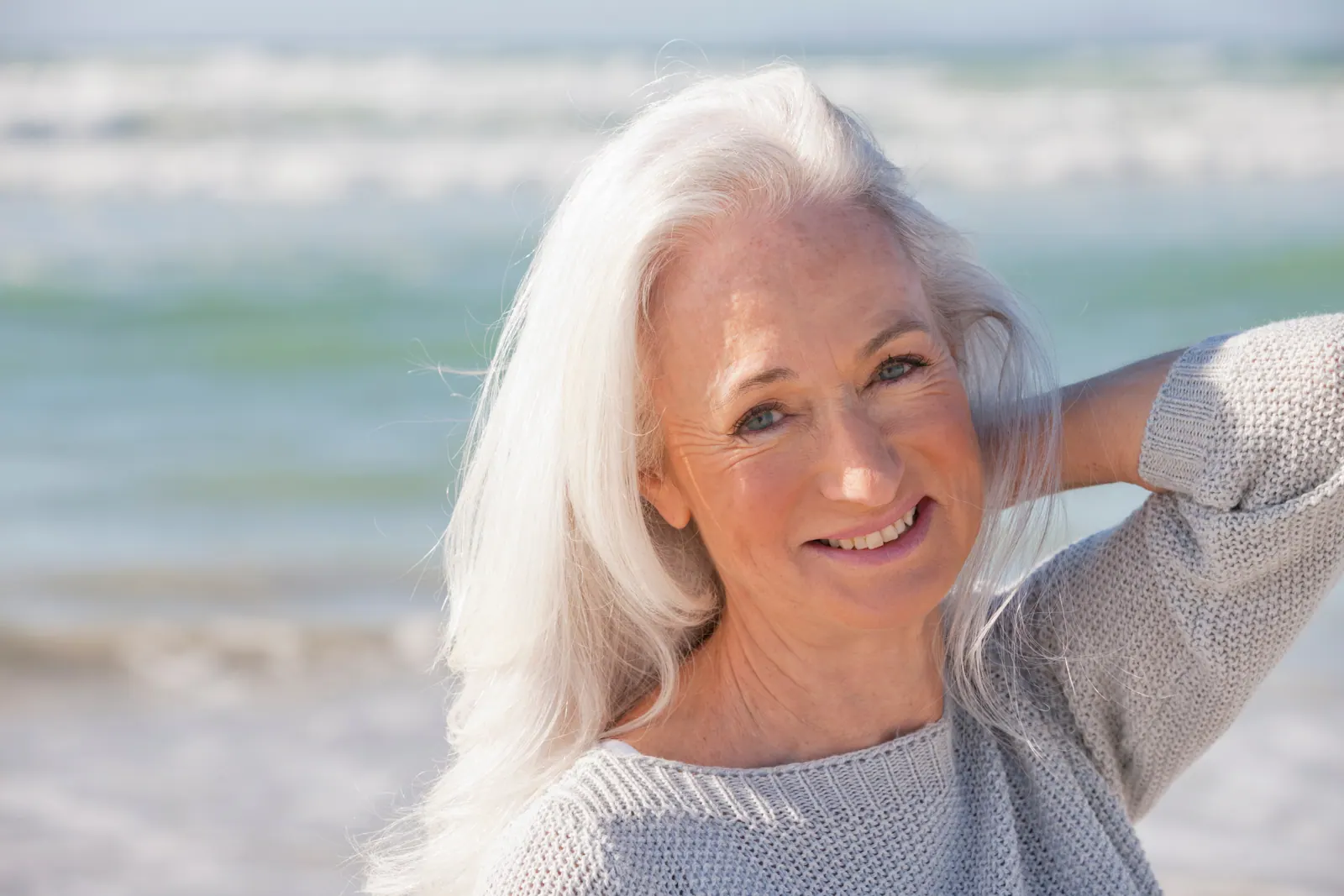 Smiling senior woman posing on the beach