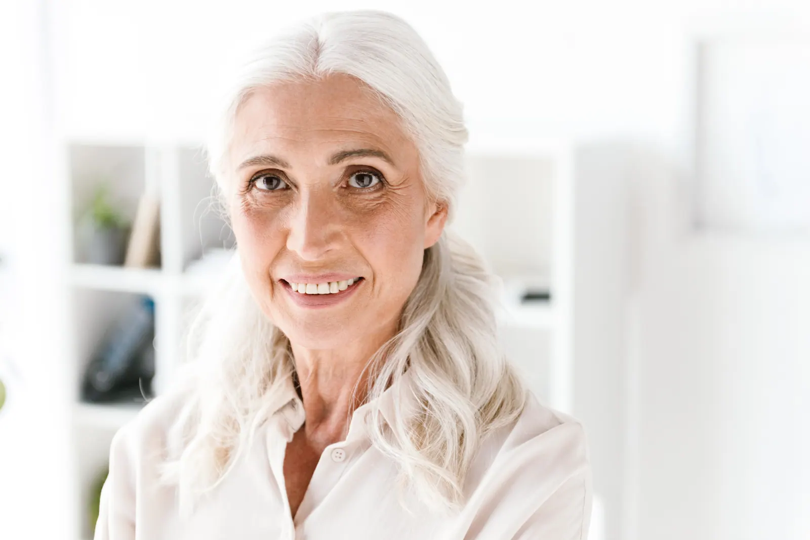 Smiling senior woman s waist up portrait indoors