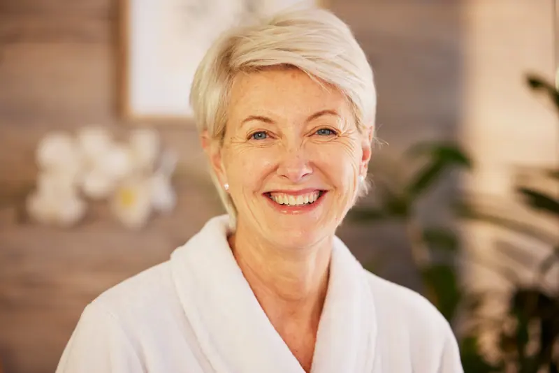 Smiling woman in bathrobe with short blonde hair