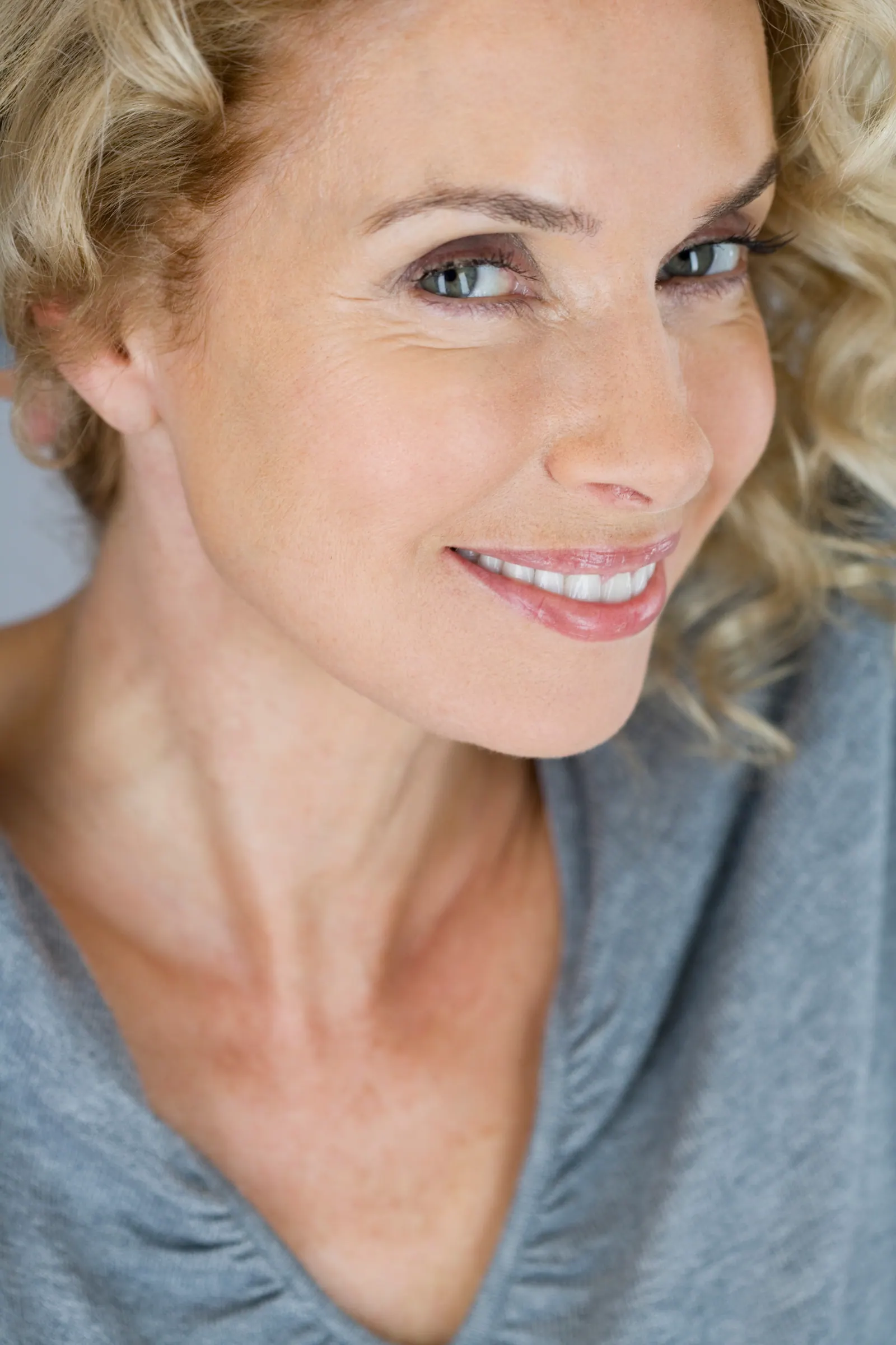 Smiling woman posing with blond curly hair