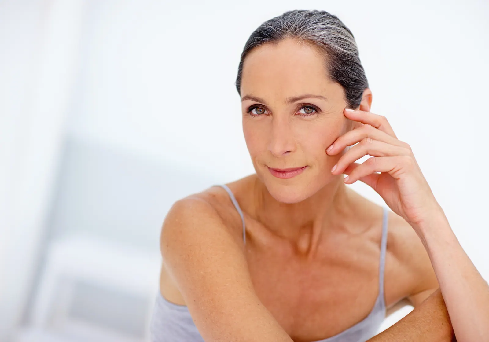 Smiling woman posing with hand to face