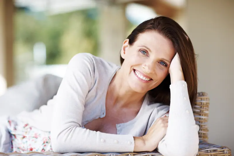 Smiling woman relaxing at home in natural light