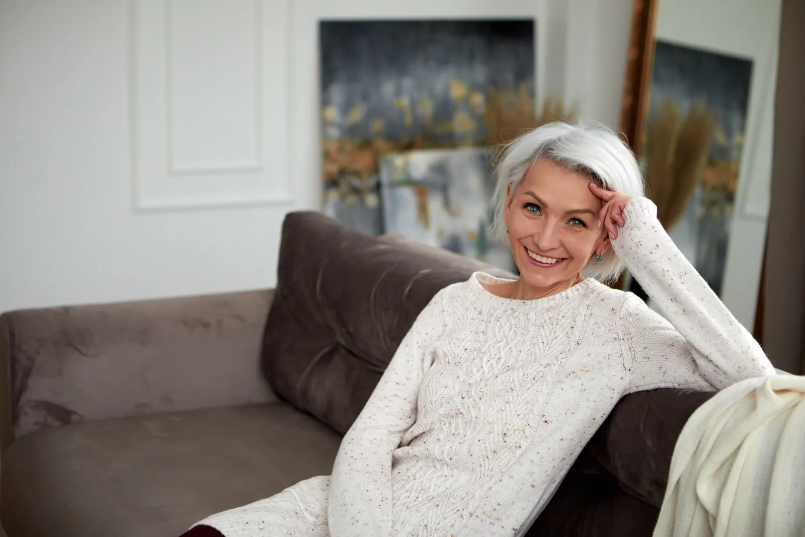 Smiling woman relaxing on sofa in living room