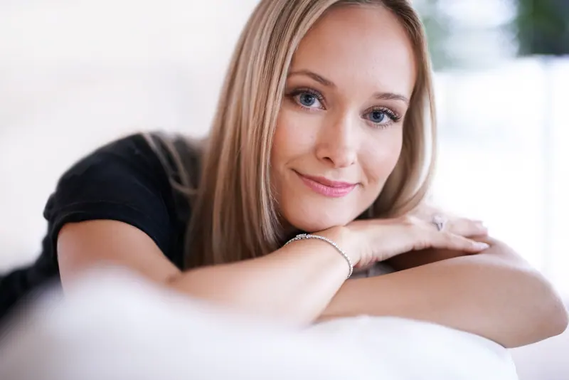 Smiling woman resting her arms on a couch
