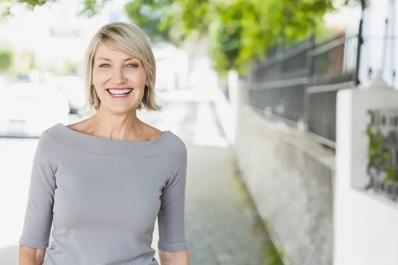 Smiling woman with blond hair outside during dayti