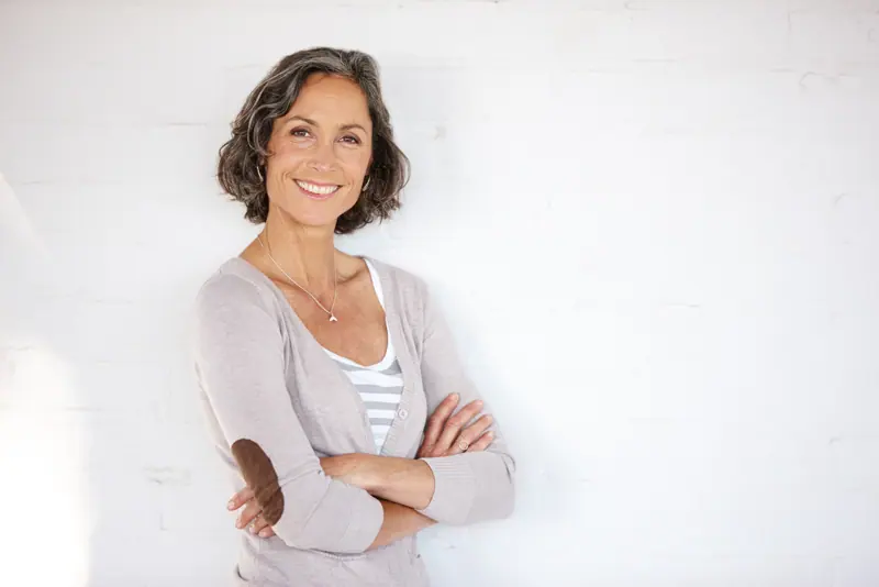 Smiling woman with gray hair and cardigan