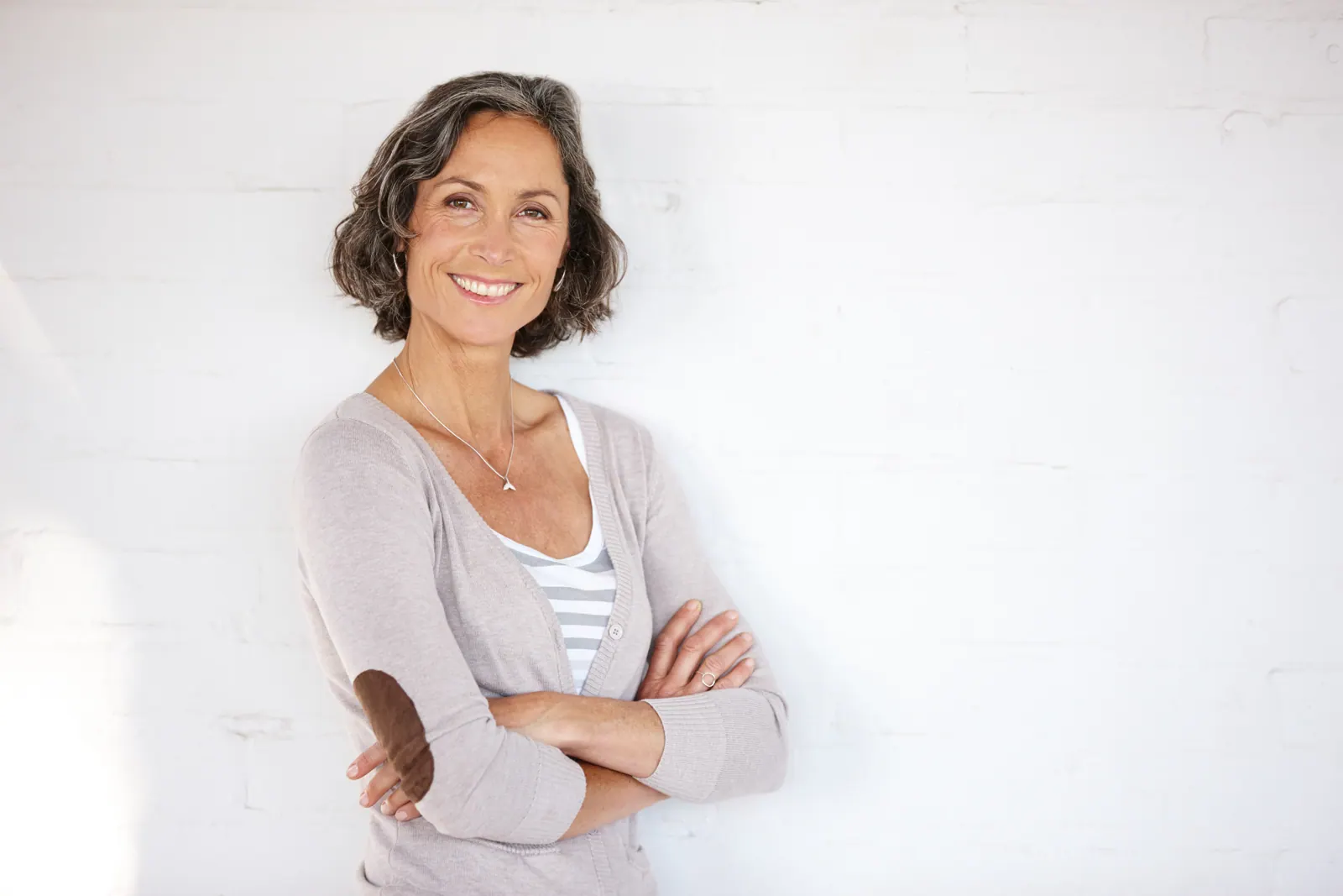 Smiling woman with gray hair and cardigan