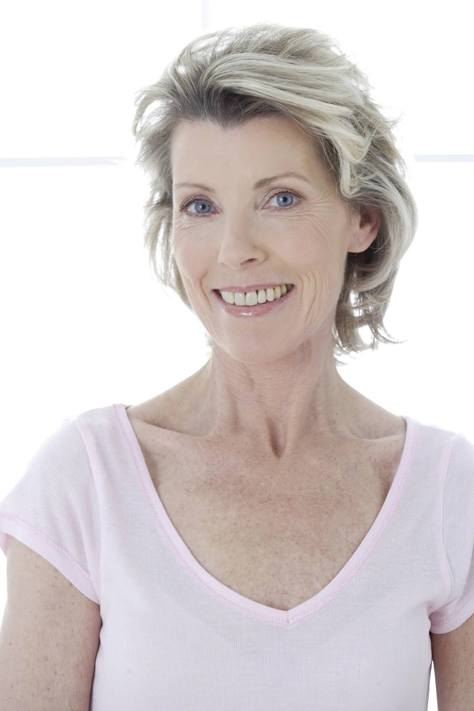 Smiling woman with grey hair in white studio