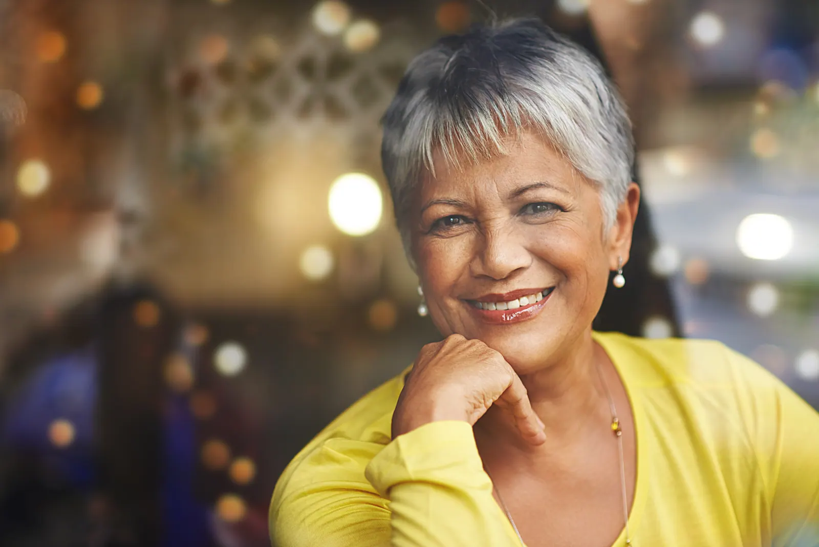 Smiling woman with grey hair posing indoors