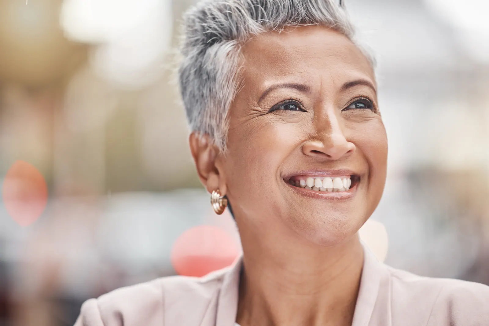 Smiling woman with short grey hair outdoors