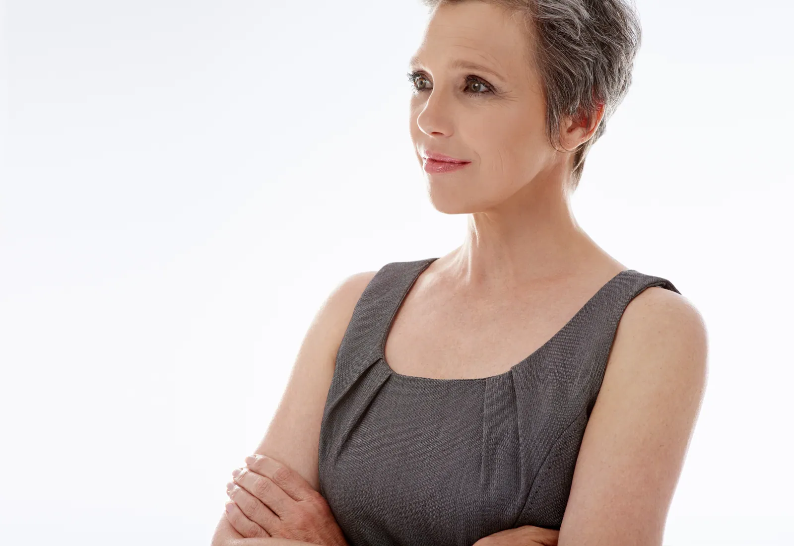 Sophisticated woman in gray dress poses calmly