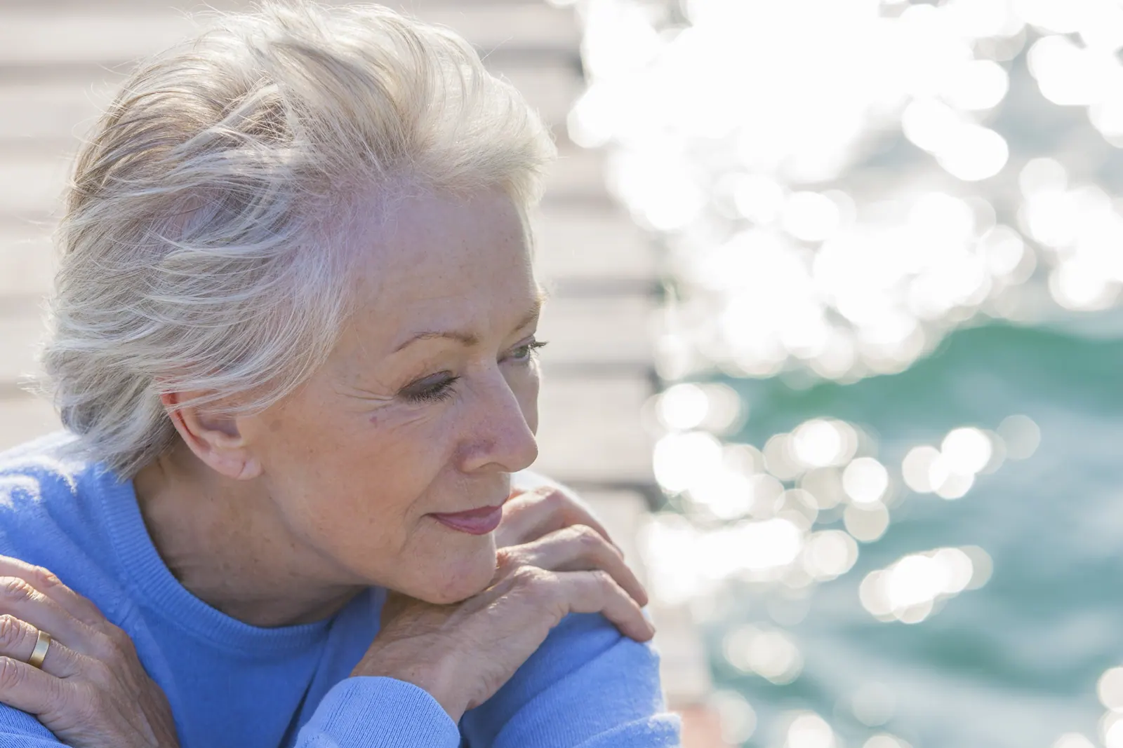 Thoughtful senior woman with grey hair at beach