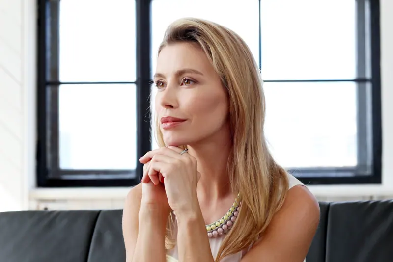Woman in thoughtful pose in home environment