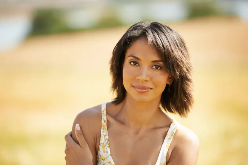 Woman poses with calm expression outdoors