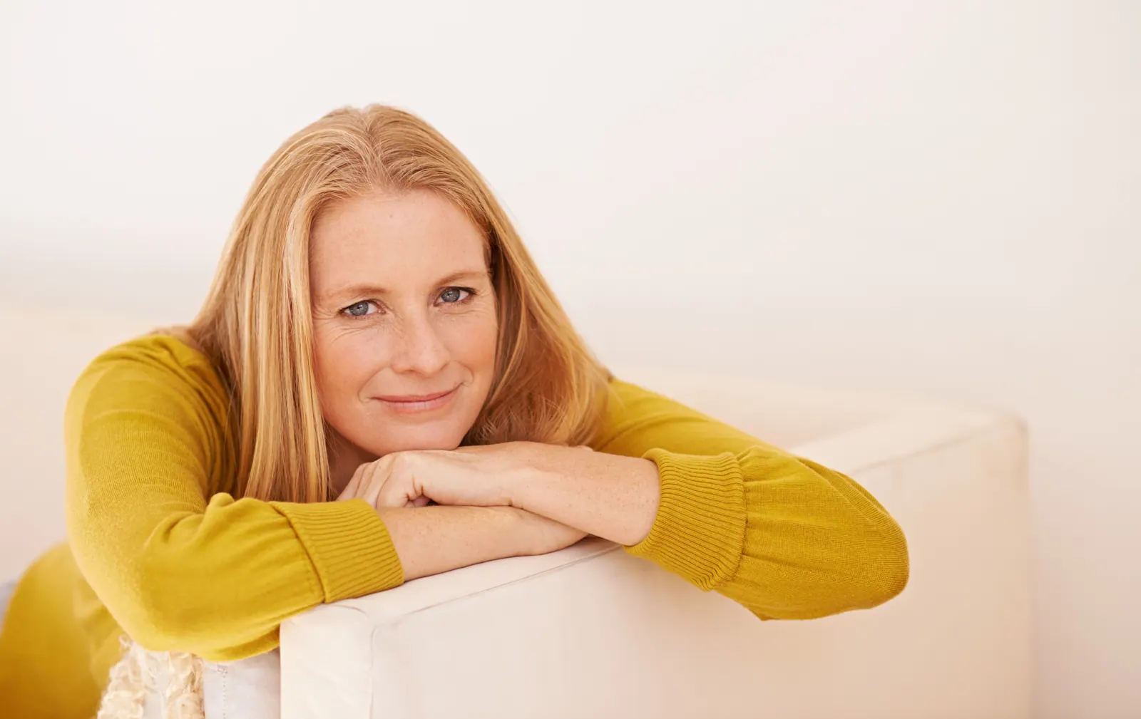 Woman posing leaning on a white couch