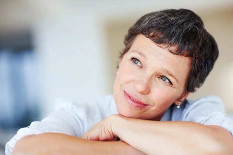 Woman relaxing indoors daydreaming and smiling