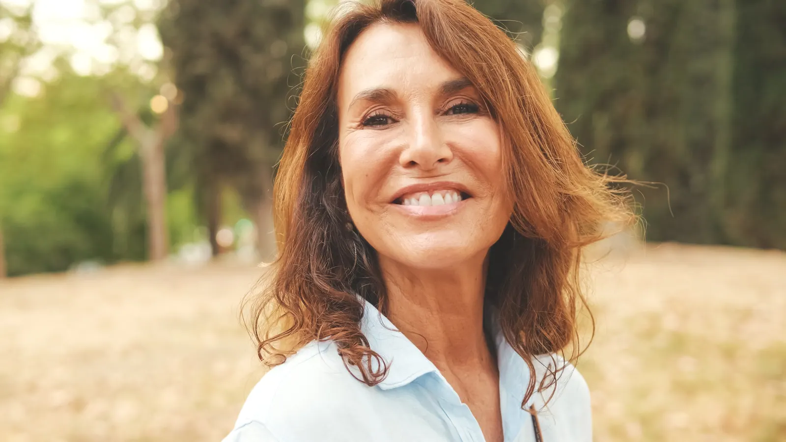 Woman smiling beautifully in park on a summer day