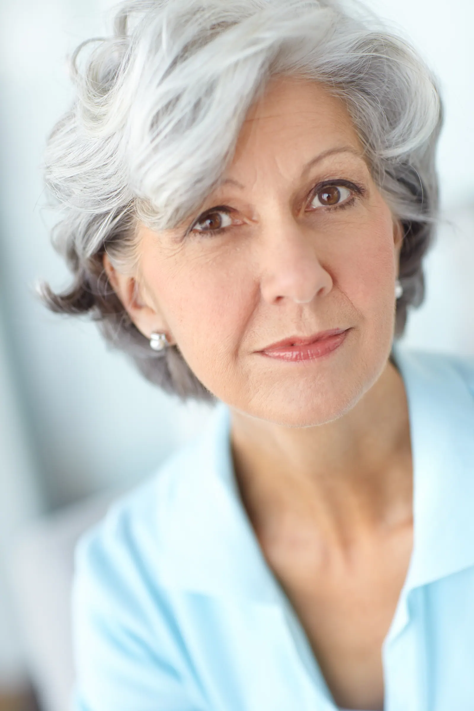 Woman smiling calmly in a light blue shirt