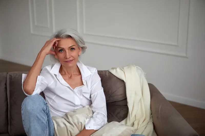 Woman with short grey hair sitting on couch